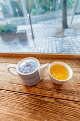 Kettle and cup of tea on the table near window