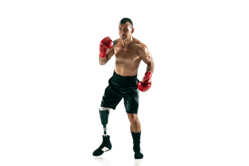 Full length portrait of muscular sportsman with prosthetic leg, copy space. Male boxer in red gloves. Isolated shot on white studio background.