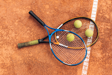 Three yellow tennis balls are lying on racket by white line
