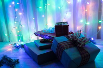Christmas presents wrapped on a table and with a background of colored lights