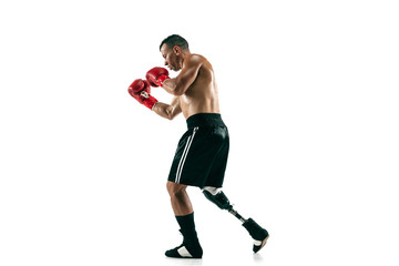 Full length portrait of muscular sportsman with prosthetic leg, copy space. Male boxer in red gloves. Isolated shot on white studio background.