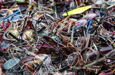 Pile of sunglasses and eyeglasses for sale in a street market