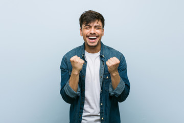 Young hispanic cool man cheering carefree and excited. Victory concept.
