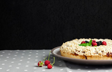 Homemade berry shortcrust pie with crumble on plate