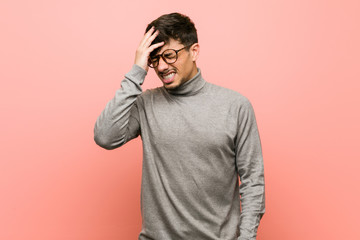Young smart student man forgetting something, slapping forehead with palm and closing eyes.
