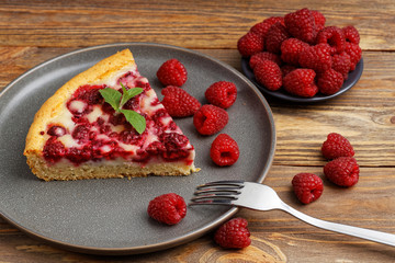 Closeup piece of homemade raspberry pie with yogurt filling on wooden table. Shallow focus.