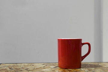 Red mug with pens over the desk in the office