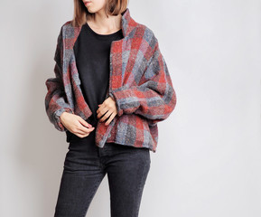 Young woman wearing simple outfit with black sweater, vintage checked jacket and black high-waisted...