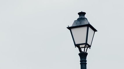 Fototapeta na wymiar old street lamp on gray sky background