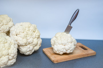 Wooden Board and knife on the kitchen table. Cut cauliflower forks. Preparation of vegetables for the winter season. The concept of home canned food and blanks. Diet food for health and slimness