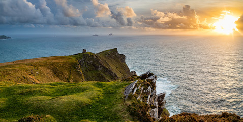 a viewpoint from bray head on valentia island in the ring of kerry in the south west coast of ireland during an autumn sunset showing the skellig islands and watchtower - obrazy, fototapety, plakaty