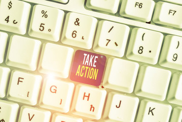 Conceptual hand writing showing Take Action. Concept meaning advices someone to do something or reaction right now White pc keyboard with note paper above the white background