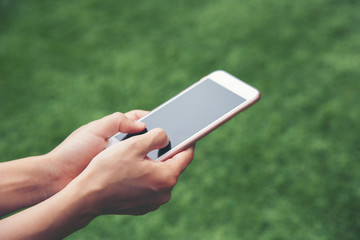 Woman using mobile smart phone on the grass for relaxing with social media