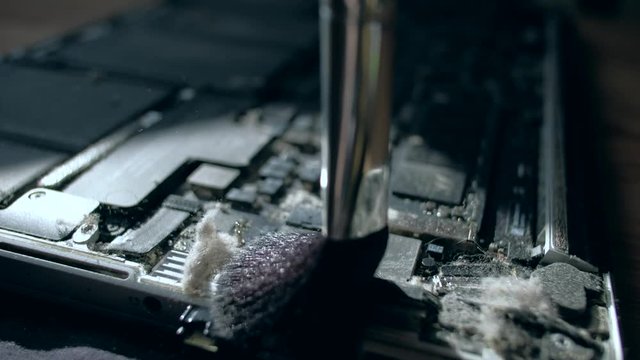 Computer Service. Master cleans the inside of the laptop with dust and other dirt. 4k. Close up. Tech Support Electronic Devices Concept.