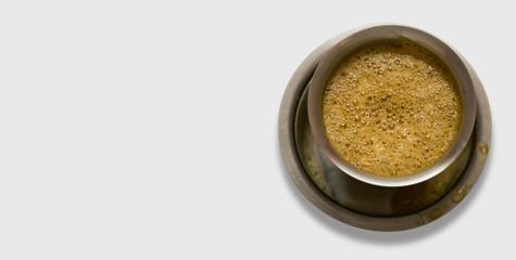 South Indian coffee served in steel glasses - white background with space for text