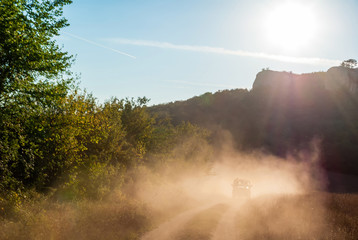 Silhouette of Chasing car in the dust