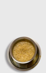 South Indian coffee served in steel glasses - white background with space for text
