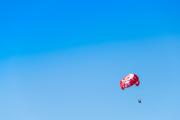 Tourists on parasailing over the Mediterranean Sea near Djerba island, Tunisia. Tunisian flag printed on the parachute.