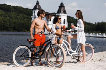Obraz premium Three friends with bicycles on the beach