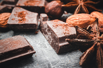 Chocolate cubes, star anise and nuts, close-up view