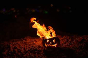 Tongues of flame in a pumpkin. jack-o-lantern on fire on a black background. Halloween symbol on the ground. Trick or treat. Close up.