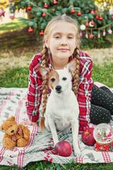 Fototapeta na wymiar Family Christmas in July. Portrait of girl near christmas tree with dog. Baby decorating pine. Winter holidays and people concept. Merry Christmas and Happy Holidays Greeting card. Christmas child. 