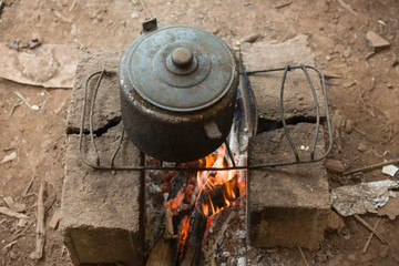 Rustic handmade oven with old iron pan over fire in a Brazilian Quilombo 