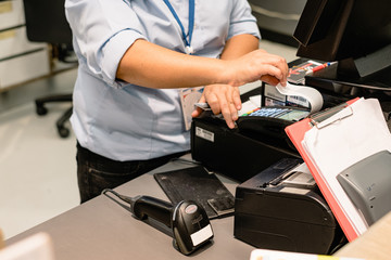 Cashier hand printing and taking receipt from pos terminal.