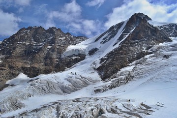 Gran Paradiso National Park, Italy. Climbing to the summit of mount Gran Paradiso 4 061 m with cats and ice ax. Sunny chilly day.