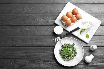 Tasty cooked spinach served on dark wooden table, flat lay with space for text. Healthy food