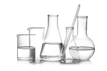 Laboratory glassware with liquid samples on white background