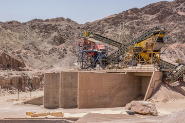 abandoned factory digging cranes and heavy industrial equipment in Middle East desert polluted natural environment human hand made quarry 