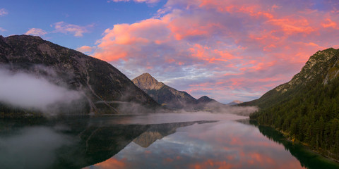 heiterwanger see lake with red sky aurora and mountains at dawn