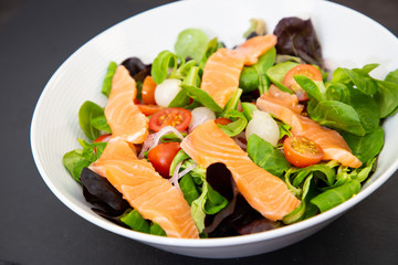 Salmon Salad mixed with spinach tomatoes, meal food delicious diet for healthy.