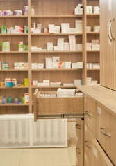open box with medicines in a pharmacy on the background of shelves with packs of pills
