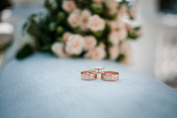 Gold wedding rings on the pink bouquet of flowers