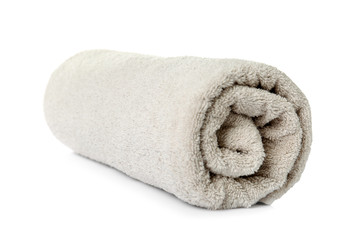 Fototapeta na wymiar Rolled clean beige towel on white background