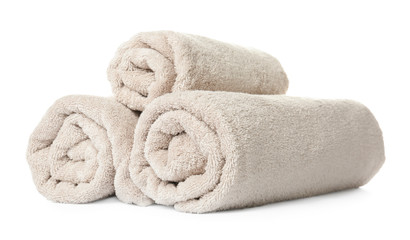 Rolled clean beige towels on white background