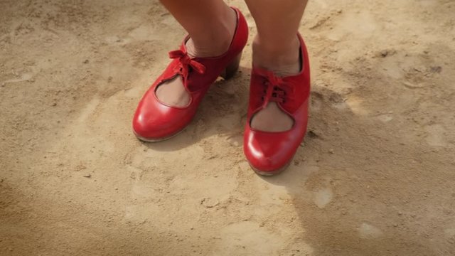 Man and woman dancing flamenco in park. Spanish people and traditional dance in Andalusia, Spain. Dancers performing traditional show in park. Couple and music arts. Closeup of female feet and costume