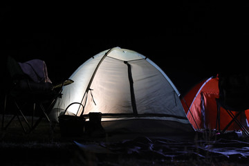 Modern camping tents in wilderness at night