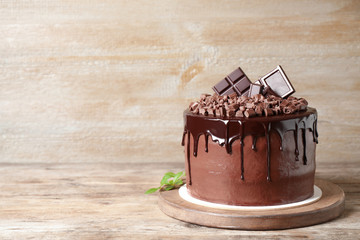 Freshly made delicious chocolate cake on wooden table. Space for text
