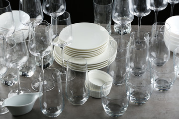 Set of empty glasses and dishware on grey table