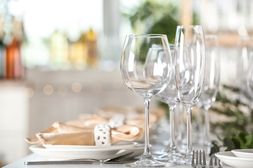 Table setting with empty glasses, plates and cutlery indoors