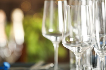 Empty glasses on blurred background, closeup. Space for text
