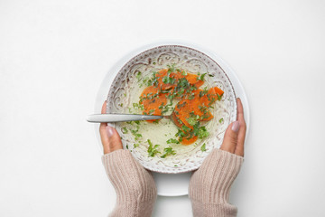 Woman with bowl of soup at white table, top view. Flu treatment