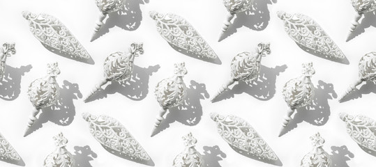 Christmas pattern with white decoration and red sparkles, confetti on white background. Xmas and New Year greeting card, winter holiday. Flat lay, top view, harsh shadow