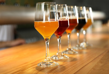 Different sorts of beer on wooden bar counter