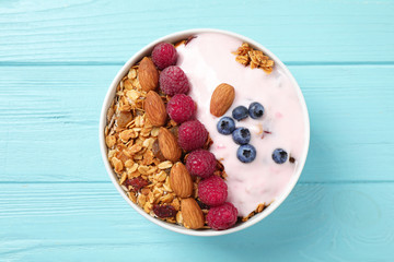Tasty homemade granola served on blue wooden table, top view. Healthy breakfast