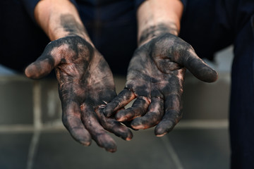 Dirty worker sitting on stairs, closeup of hands