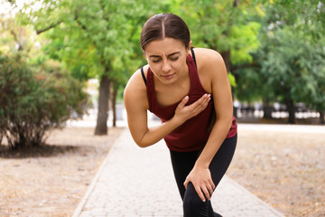 Young woman having heart attack while running in park